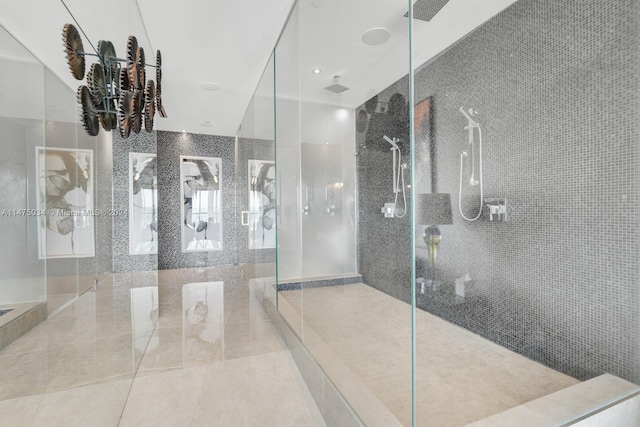 bathroom with a shower with shower door and tile floors