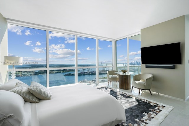 bedroom featuring a water view and a wall of windows