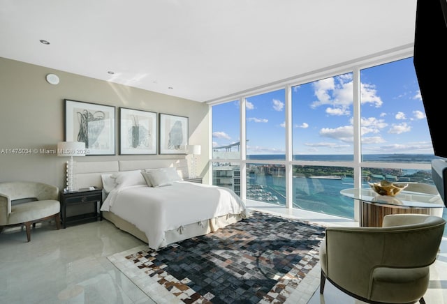 bedroom featuring a water view, a wall of windows, tile floors, and multiple windows