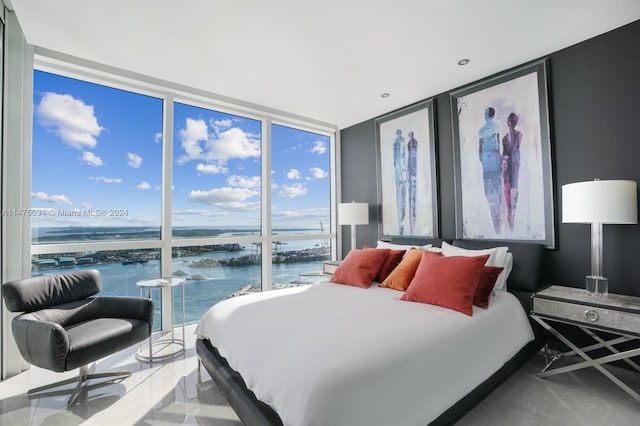 bedroom featuring a water view and expansive windows