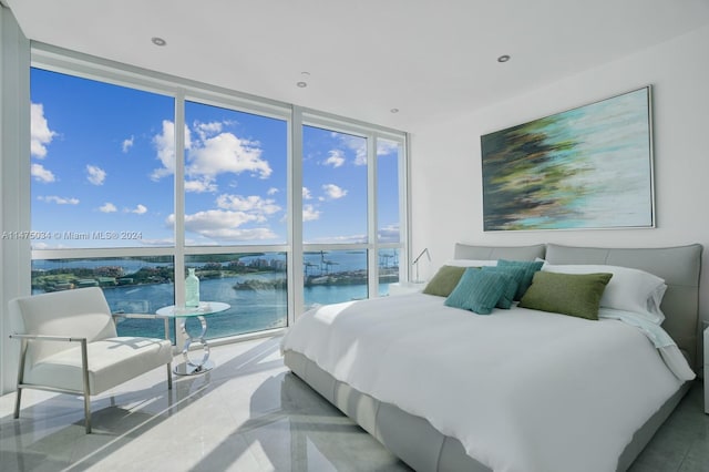 tiled bedroom featuring a water view, expansive windows, and multiple windows