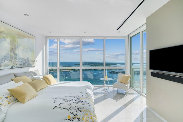 bedroom featuring tile flooring, a wall of windows, and a water view