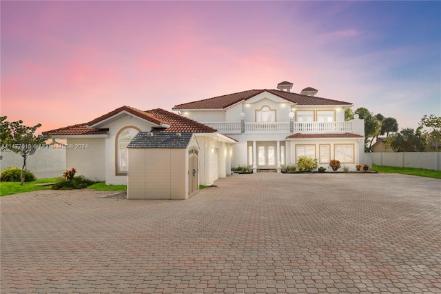 mediterranean / spanish-style home with a garage and a balcony