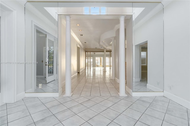 corridor featuring crown molding, decorative columns, and light tile patterned floors