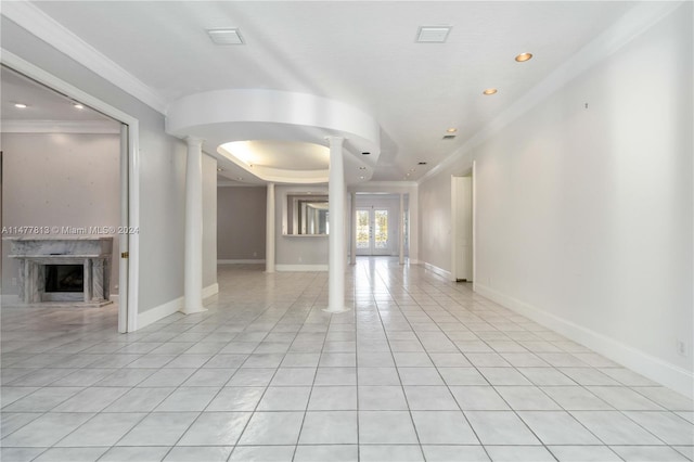 tiled empty room featuring crown molding, decorative columns, and a fireplace