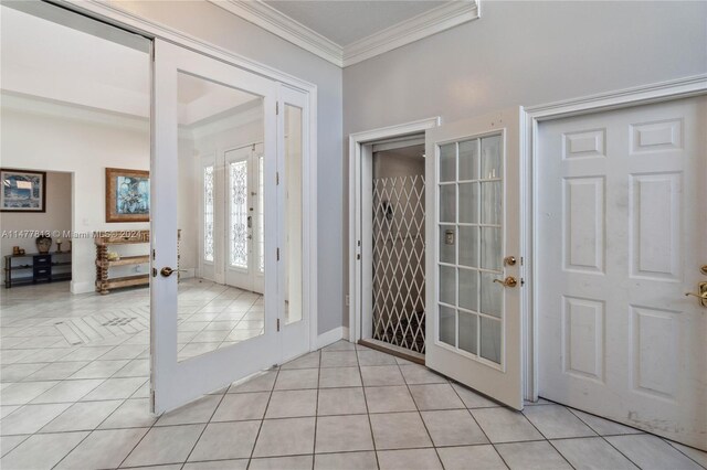 foyer entrance featuring ornamental molding, french doors, and light tile patterned floors