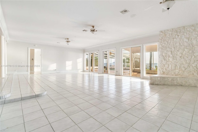 spare room featuring crown molding, light tile patterned floors, and ceiling fan