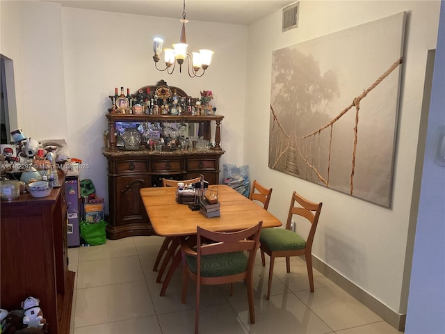 dining room with a chandelier and light tile flooring