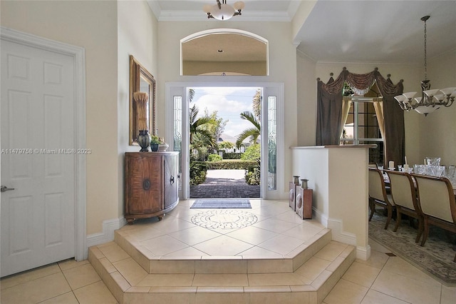 tiled entrance foyer featuring ornamental molding and a notable chandelier