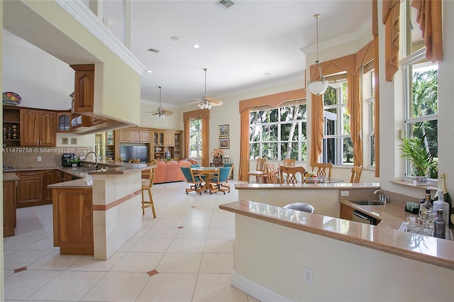 kitchen with hanging light fixtures, ceiling fan, and kitchen peninsula