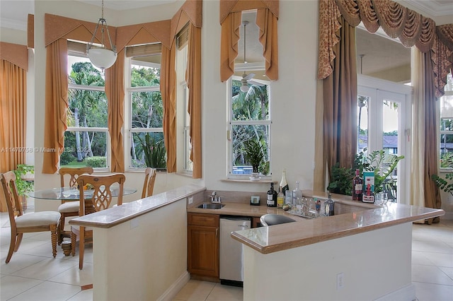 kitchen featuring light tile flooring, kitchen peninsula, ornamental molding, hanging light fixtures, and dishwasher