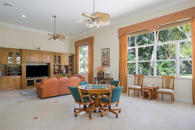 tiled dining room featuring plenty of natural light, crown molding, and ceiling fan