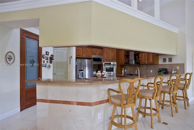 kitchen with kitchen peninsula, light tile floors, backsplash, stainless steel appliances, and a high ceiling