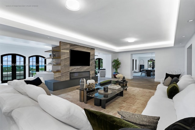 living room featuring a fireplace, french doors, and a raised ceiling