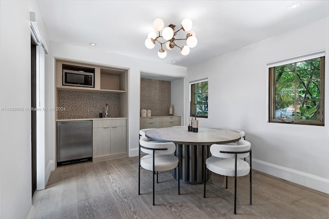 dining room with a chandelier, light hardwood / wood-style floors, and sink