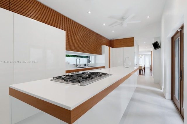 kitchen with sink, white cabinetry, ceiling fan, and stainless steel gas stovetop