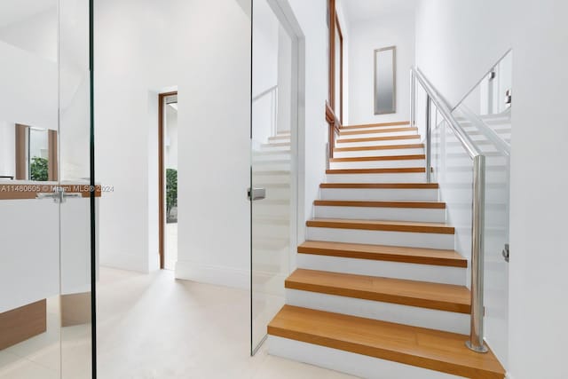 staircase featuring a towering ceiling