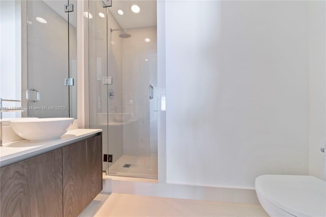 bathroom featuring vanity, tile flooring, a shower with shower door, and toilet