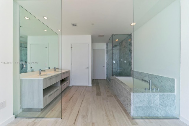 bathroom featuring hardwood / wood-style flooring, walk in shower, and vanity