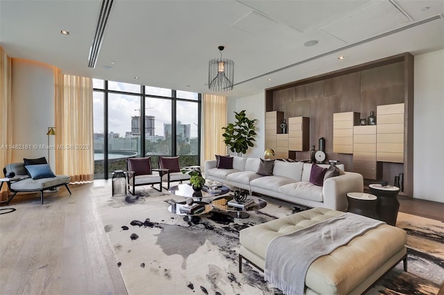 living room featuring an inviting chandelier, hardwood / wood-style floors, and expansive windows