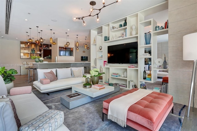 living room featuring a chandelier, built in features, and dark wood-type flooring