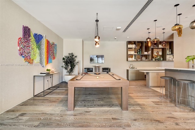 game room with bar area, pool table, and light hardwood / wood-style floors