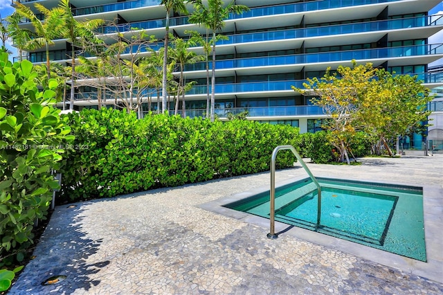 view of swimming pool featuring a hot tub