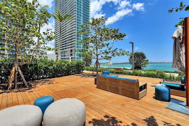 wooden deck with a water view and a jacuzzi