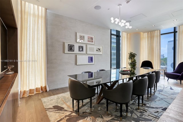 dining room with expansive windows, a chandelier, and light hardwood / wood-style flooring