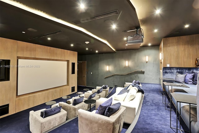 home theater featuring wood walls and dark colored carpet