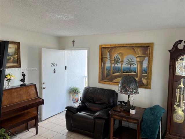 sitting room with a textured ceiling and light tile floors