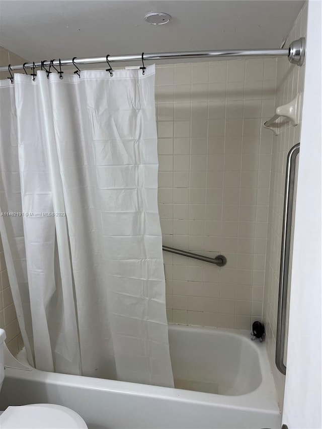 bathroom with shower / tub combo and toilet