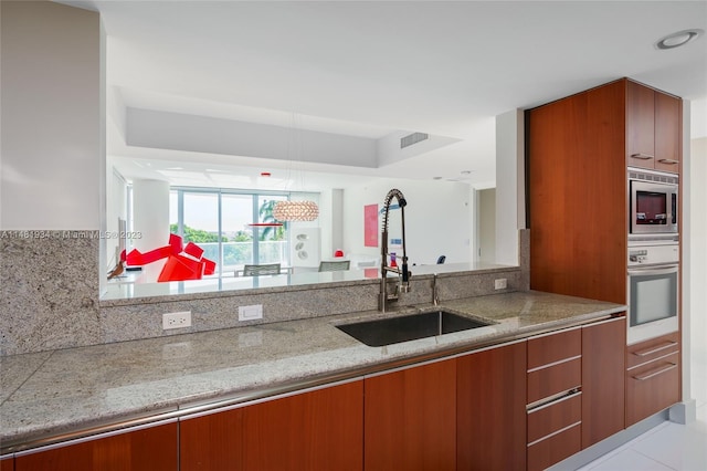 kitchen featuring sink, light tile floors, appliances with stainless steel finishes, light stone countertops, and tasteful backsplash