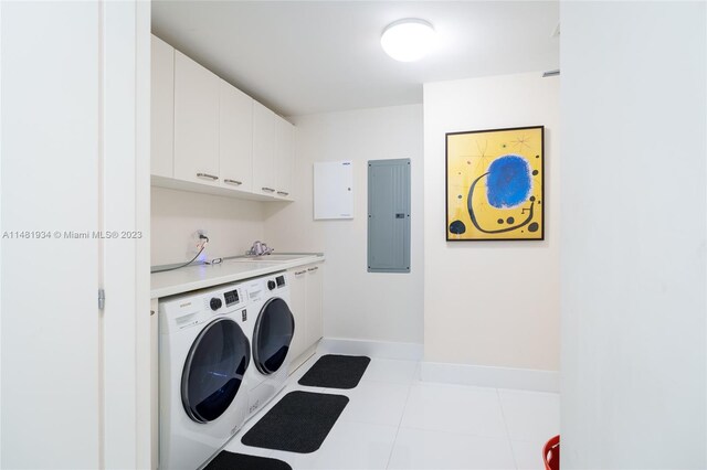 washroom featuring light tile floors, sink, cabinets, and independent washer and dryer