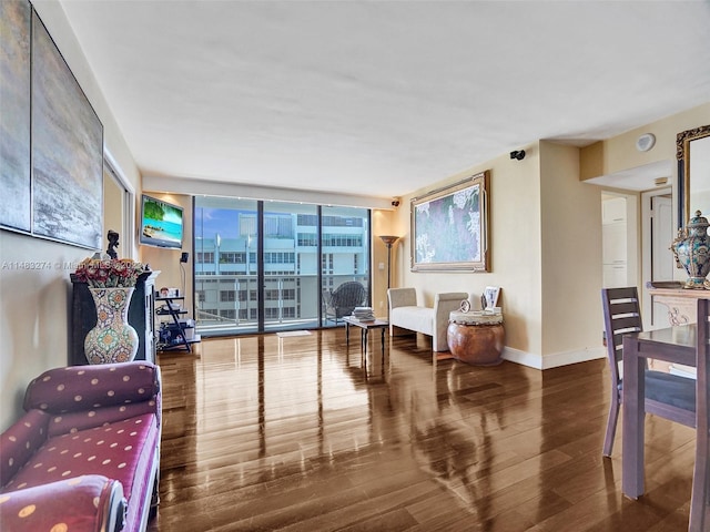 living area with hardwood / wood-style flooring and expansive windows