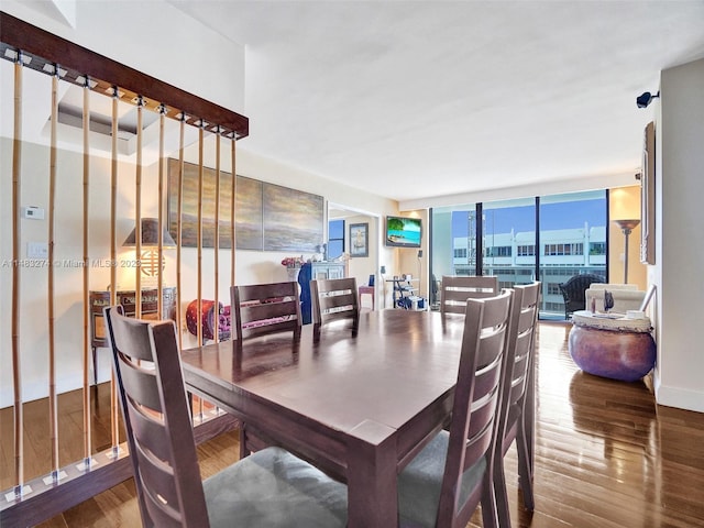 dining room with floor to ceiling windows and hardwood / wood-style floors