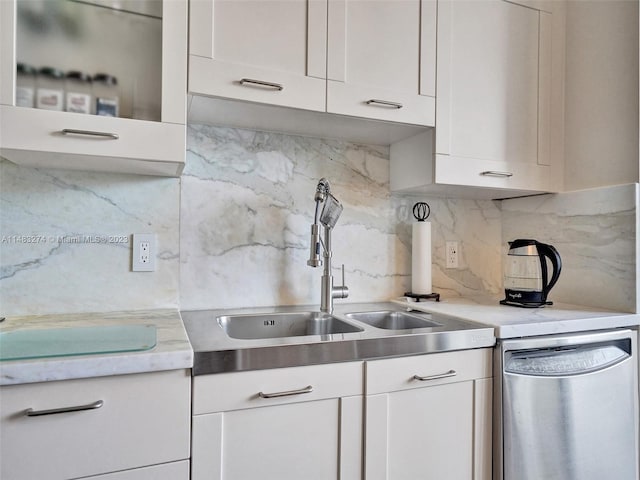 kitchen featuring sink, decorative backsplash, stainless steel dishwasher, and white cabinets