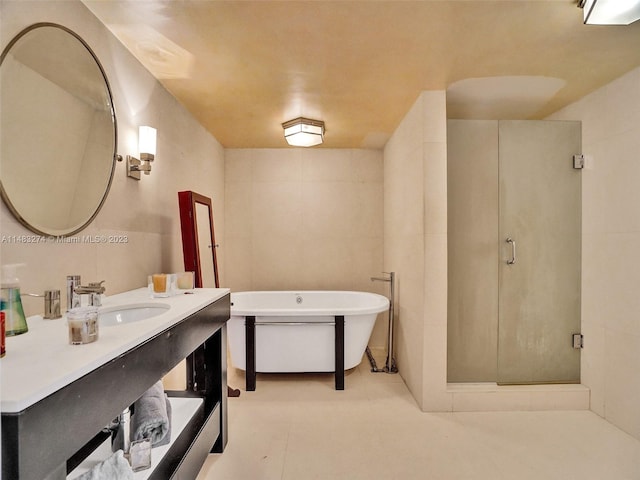 bathroom featuring independent shower and bath, vanity, tile patterned flooring, and tile walls