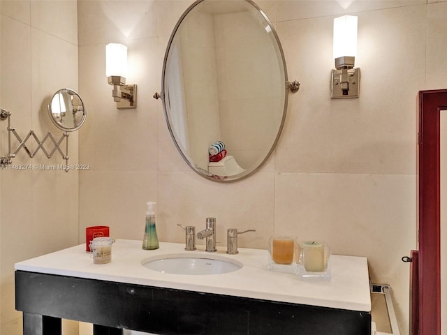 bathroom featuring vanity and tile walls