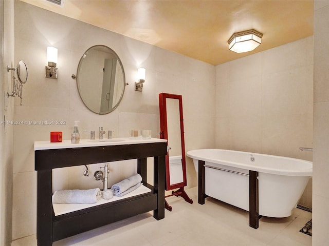 bathroom featuring a tub, sink, and tile walls