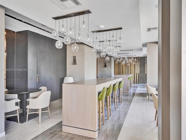 kitchen with hanging light fixtures, a kitchen island, and a kitchen breakfast bar