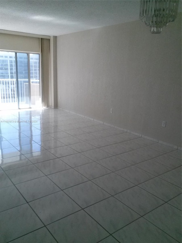 unfurnished room featuring tile patterned flooring and a textured ceiling