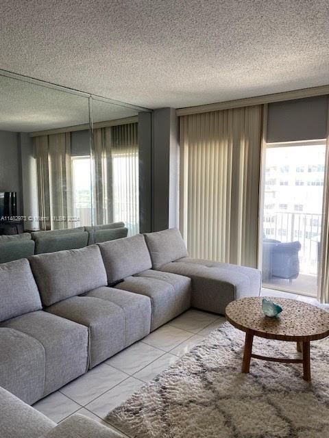 living room featuring a textured ceiling and tile patterned floors