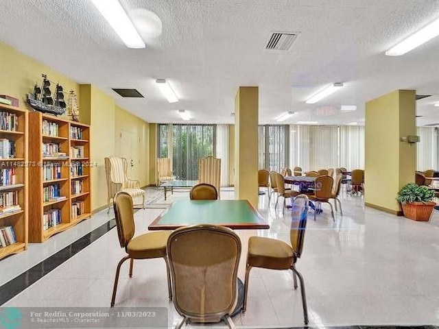 tiled dining area with a textured ceiling