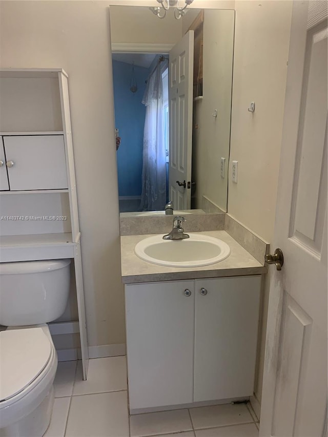 bathroom with toilet, tile flooring, and vanity