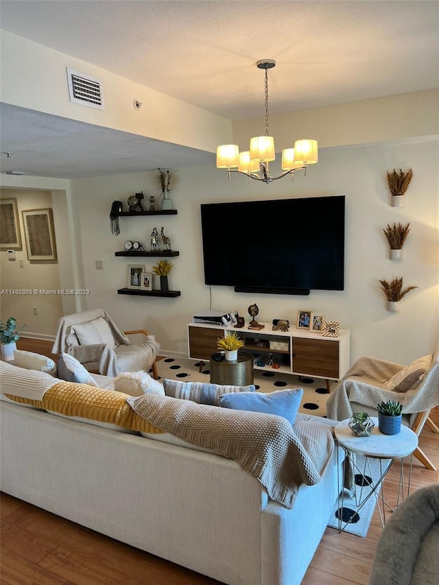 living room featuring a chandelier and light hardwood / wood-style flooring