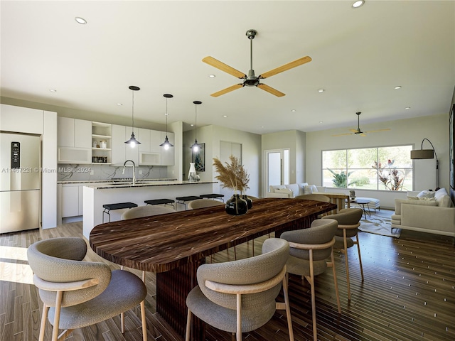 dining area with ceiling fan, hardwood / wood-style flooring, and sink