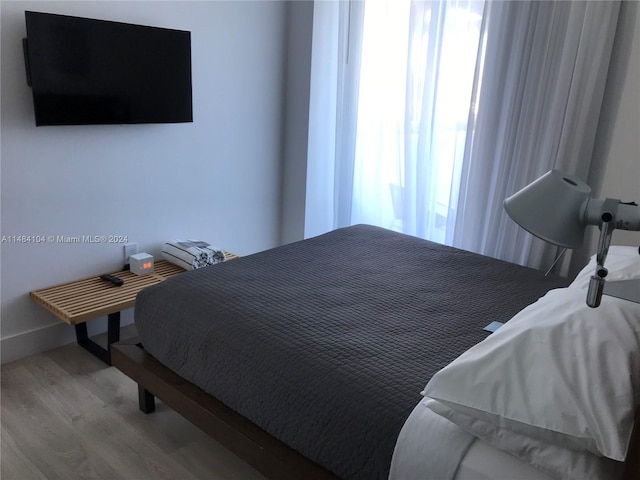 bedroom featuring hardwood / wood-style flooring and multiple windows