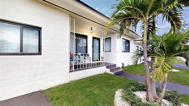 property entrance with a yard and a porch