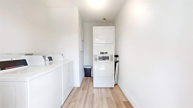 washroom featuring light hardwood / wood-style flooring, stacked washer and clothes dryer, and washing machine and dryer